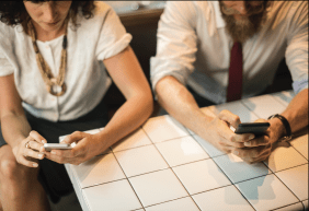 two people holding phones